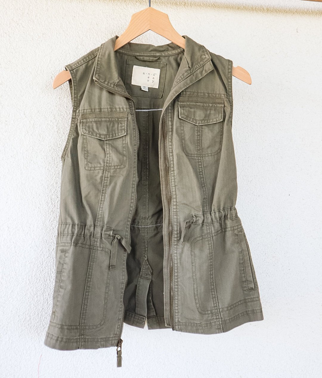 Angled back view of an olive-green vest showing its repurposed vintage Nebaj huipil panel