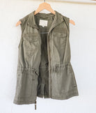 Angled back view of an olive-green vest showing its repurposed vintage Nebaj huipil panel