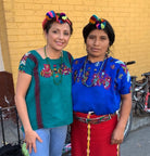 Traditional Chajul hair wrap with a plum-purple cord and four multicolored pom-poms arranged on a cream background