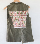 Angled back view of an olive-green vest showing its repurposed vintage Nebaj huipil panel