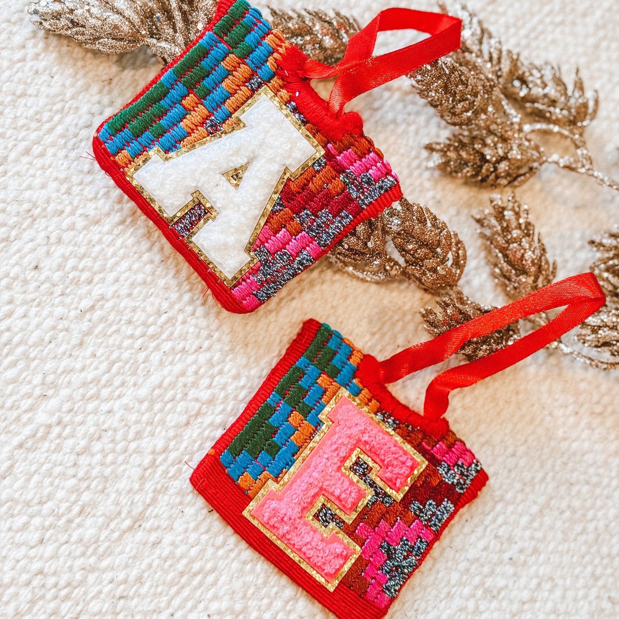 Personalized Guatemalan Huipilito ornaments with A and E initial letters, made from colorful repurposed vintage textile fabric