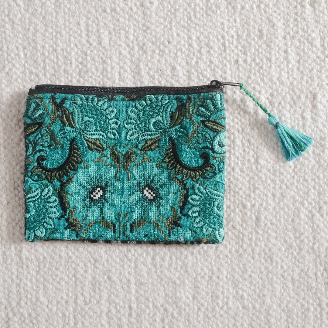 A medium-sized blue and green coin pouch with a zippered closure and a leather tassel, handcrafted from a traditional Guatemalan textile.
